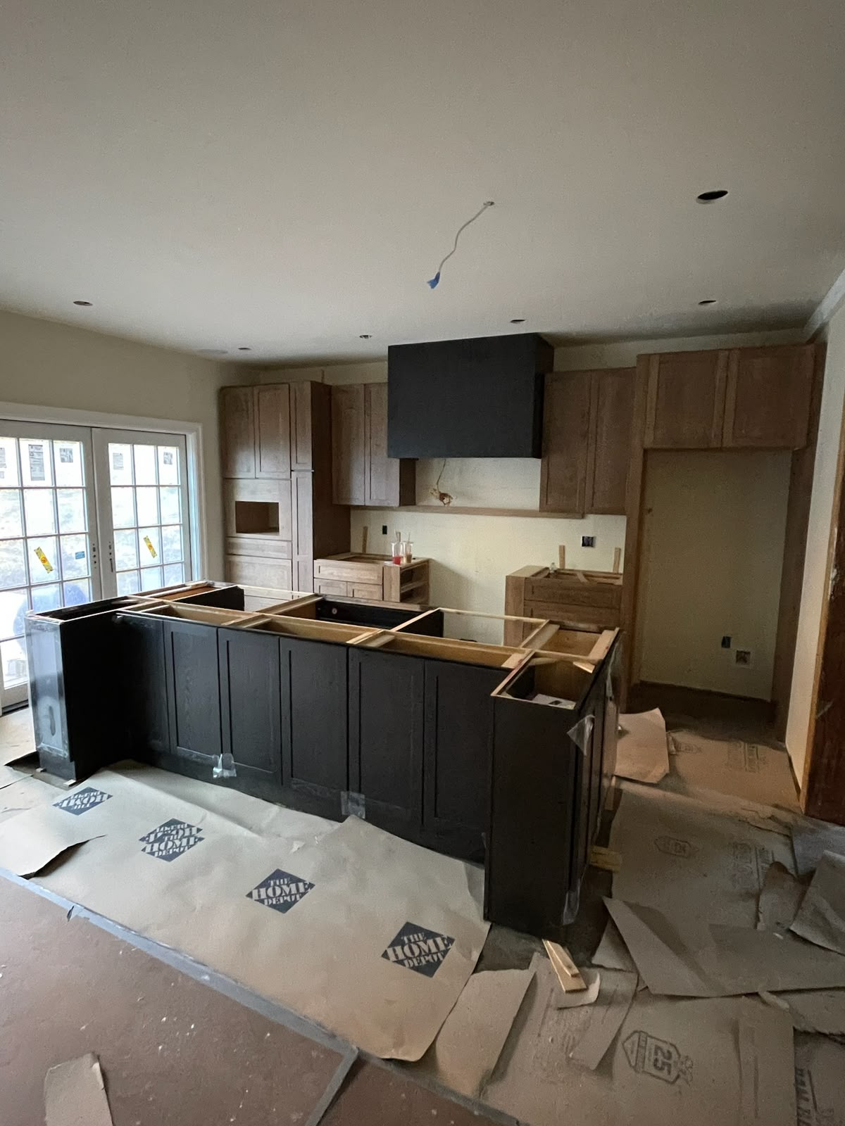 Two-tone kitchen with dark island and custom hood surround