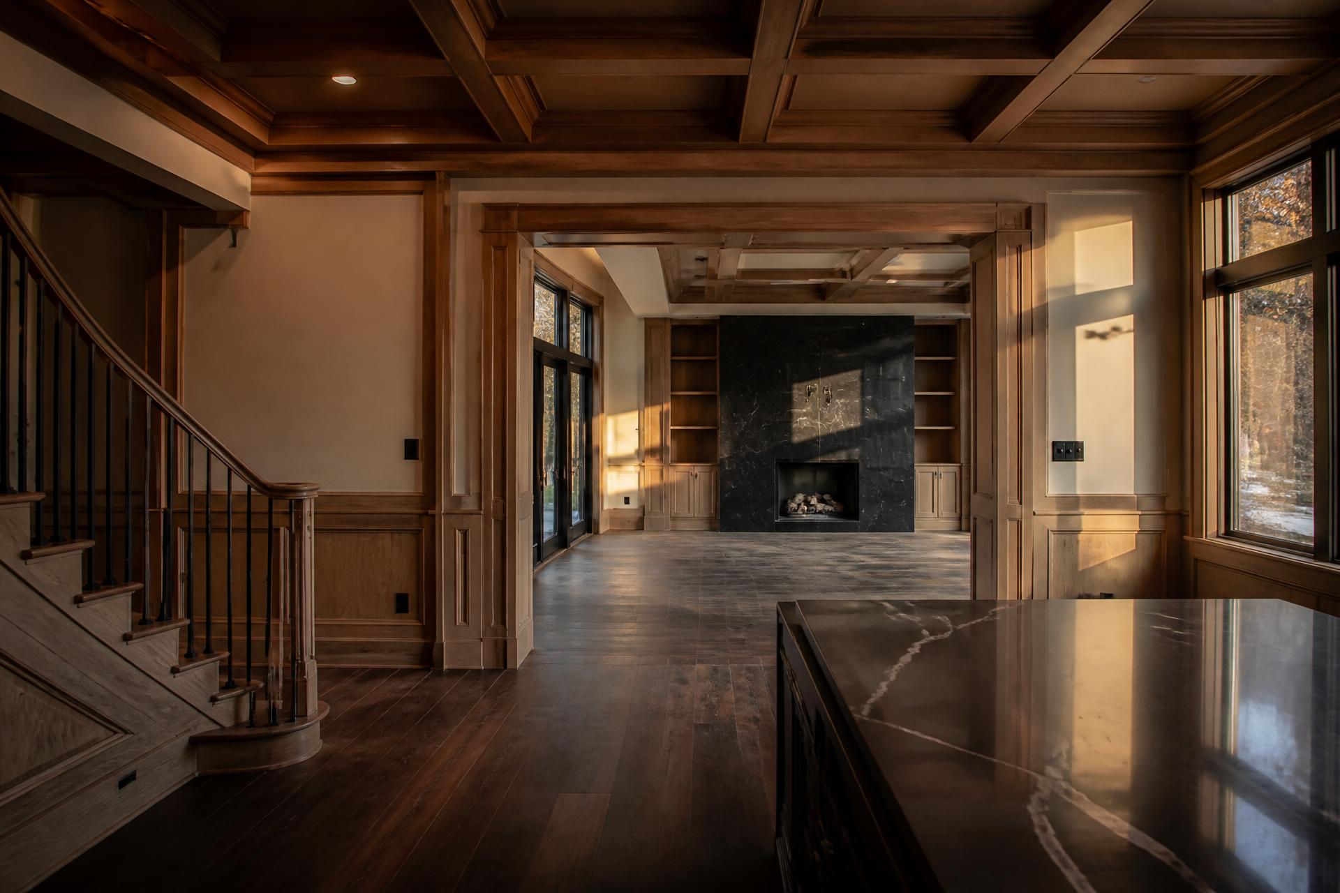 Luxury home interior with custom coffered ceilings, wood trim and stone fireplace remodeled in Massachusetts